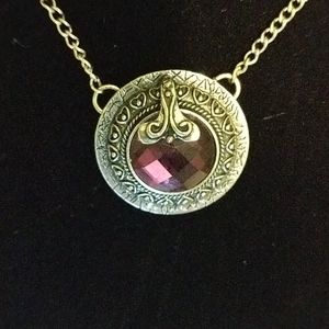 Purple glass jewel in ornate silver setting